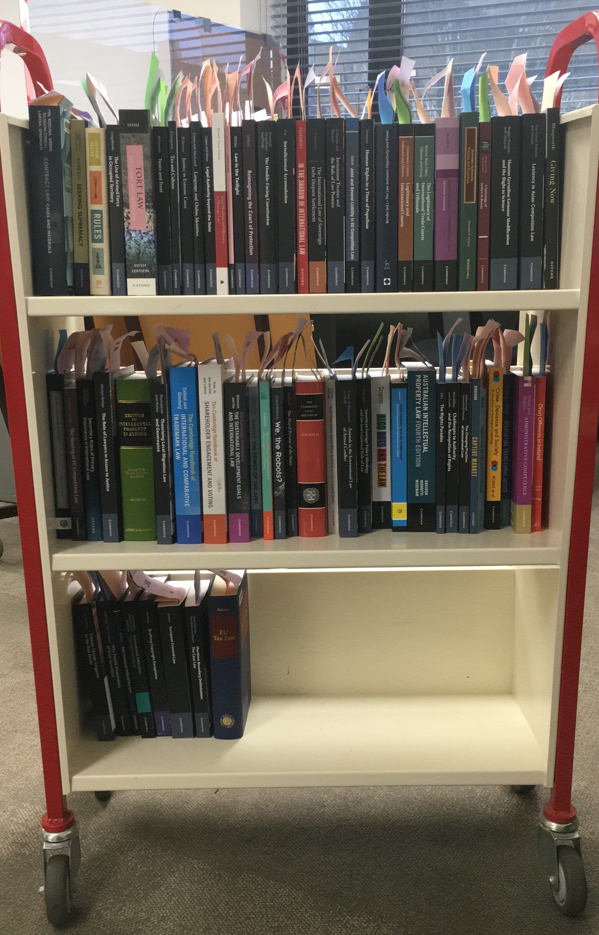 A large white and red trolley with its three shelves filled by VBD books.